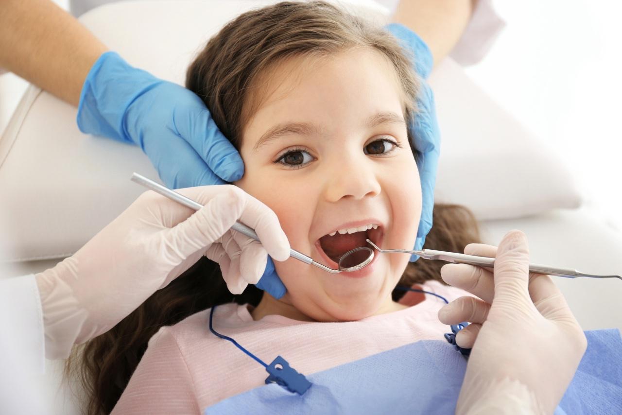 Niña sonriendo durante una revisión dental de odontopediatría