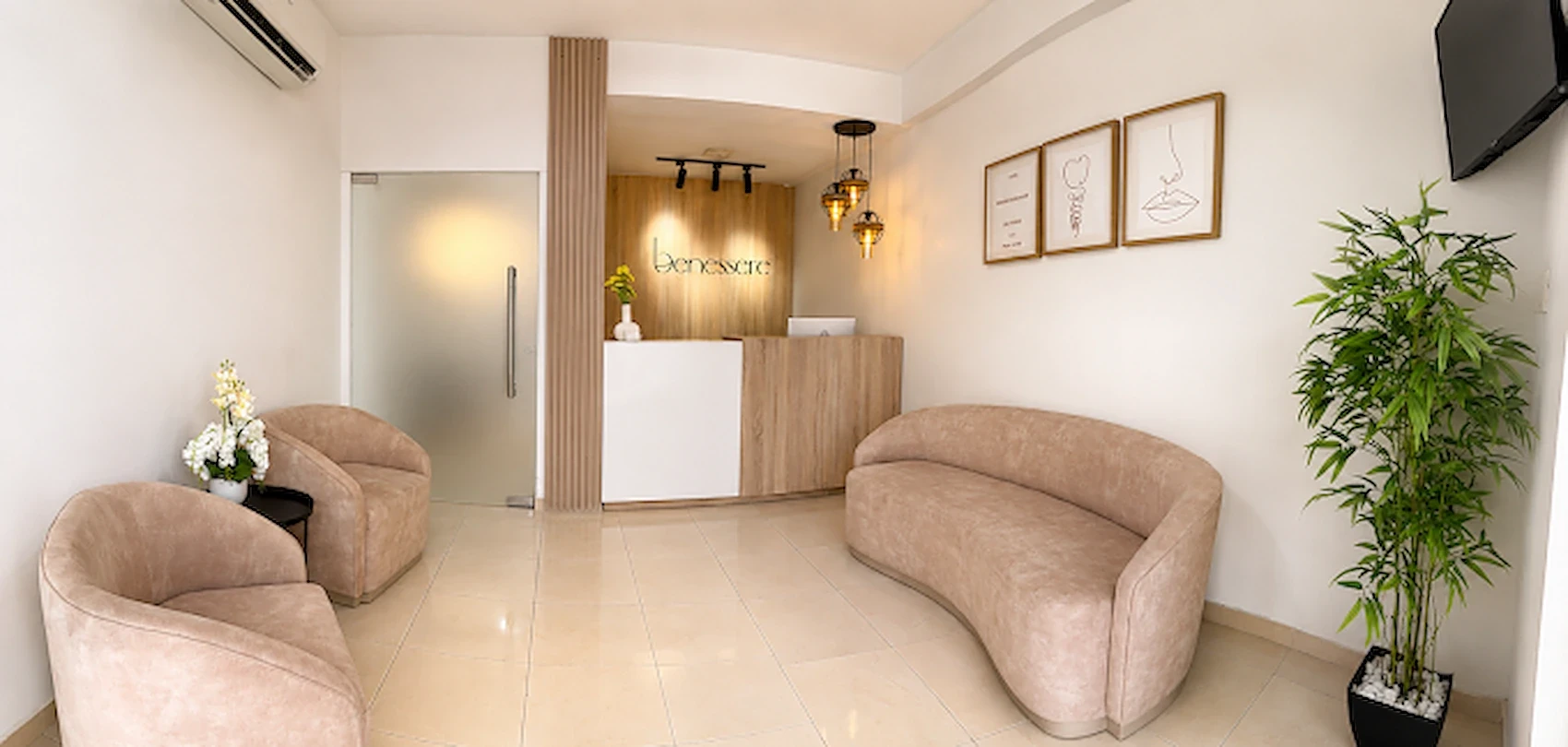Entrada y recepción de Benessere Clinic, con el mostrador, el logotipo de la clínica y la sala de espera