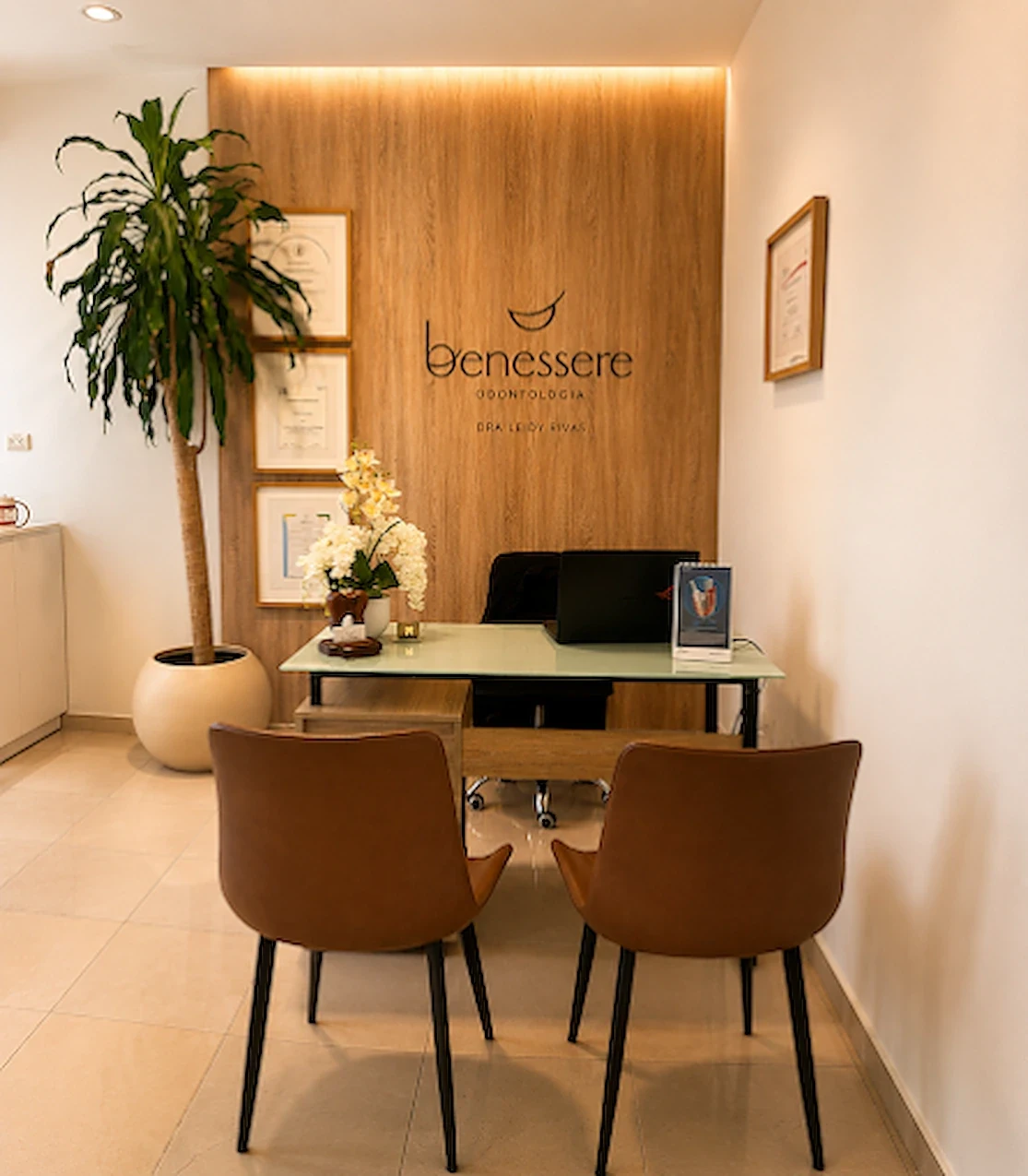 Recepción de Benessere Clinic en Esperanza, con el logotipo de la clínica sobre panel de madera